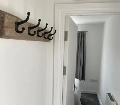 a room with a door with a mirror and a bedroom at Newquay Beachcomber, 1 bedroom apartment in Saint Columb Minor