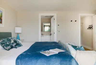 a bedroom with a large bed with a blue blanket at Heron House in Newquay