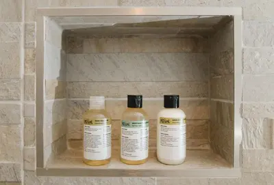 three bottles of essential oils in a bathroom shelf at Heron House in Newquay