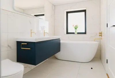 a bathroom with a tub and a sink and a toilet at Heron House in Newquay