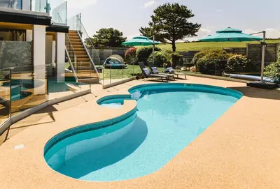 a swimming pool in front of a house at Heron House in Newquay