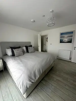 a white bedroom with a large bed in it at Stylish beachfront penthouse in Perranporth