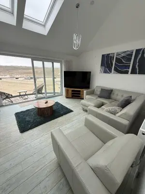 a living room with a couch and a flat screen tv at Stylish beachfront penthouse in Perranporth