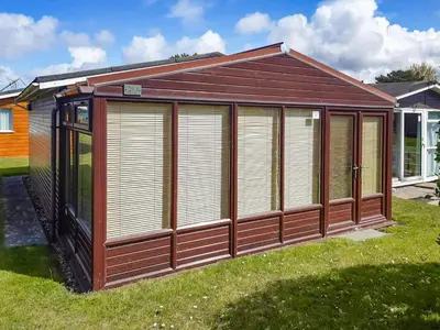 a brown and white building in the grass at Atlantic Retreat in Padstow