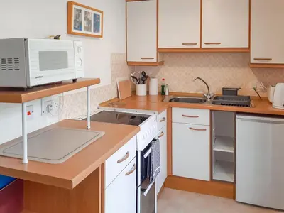 a kitchen with white cabinets and a microwave at Atlantic Retreat in Padstow