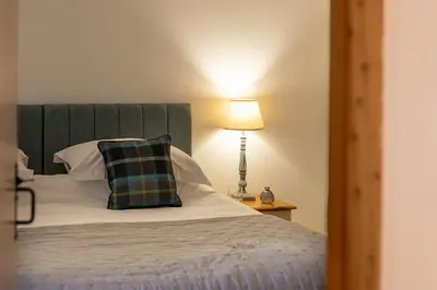 a bedroom with a bed with a pillow and a lamp at Riverside barn on private wildlife estate in Washaway