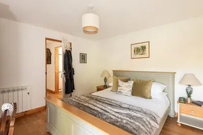 a bedroom with a bed with a wooden headboard at Riverside barn on private wildlife estate in Washaway