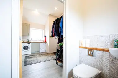 a bathroom with a toilet and a sink and a washing machine at Tregaron in Penryn
