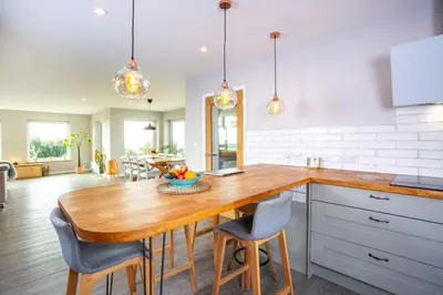 a kitchen with a wooden table and chairs at Tregaron in Penryn