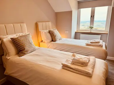 a bedroom with two beds with towels on them at Tregaron in Penryn