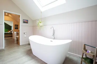a white bath tub in a bathroom with a skylight at Tregaron in Penryn