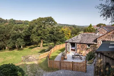 an external view of a cottage with a wooden fence at Riverside cottage on private wildlife estate 1-bed in Washaway