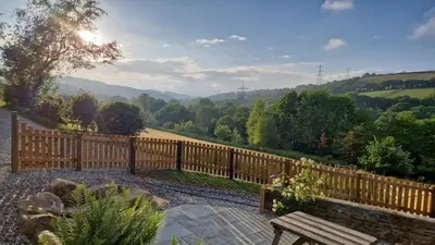 a wooden fence with a bench in a garden at Riverside cottage on private wildlife estate 1-bed in Washaway