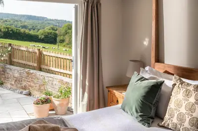 a bedroom with a bed and a window with a view at Riverside cottage on private wildlife estate 2-bed in Washaway