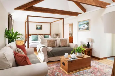 a living room with a couch and a bed at Riverside cottage on private wildlife estate 3-bed in Washaway