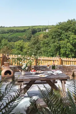 a wooden table sitting on top of a patio at Riverside cottage on private wildlife estate 3-bed in Washaway