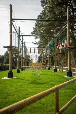 an empty park with a playground with a bunch of swings at The Vacation, Cozy Static Caravan in Newquay in Newquay