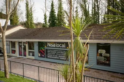 a nissanocal building with a fence in front of it at The Vacation, Cozy Static Caravan in Newquay in Newquay