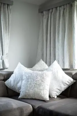 a couch with two pillows on it in a living room at The Vacation, Cozy Static Caravan in Newquay in Newquay