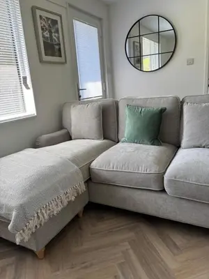 a living room with a couch and a mirror at 85 Strawberry Hill Hayle in Hayle
