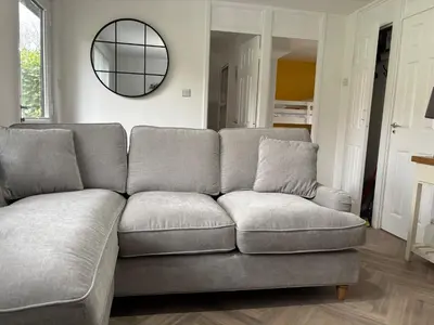 a gray couch in a living room with a mirror at 85 Strawberry Hill Hayle in Hayle