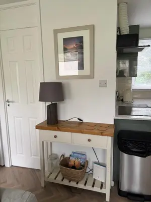 a table with a lamp on it next to a door at 85 Strawberry Hill Hayle in Hayle