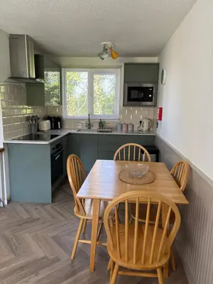 a kitchen with a wooden table and chairs at 85 Strawberry Hill Hayle in Hayle