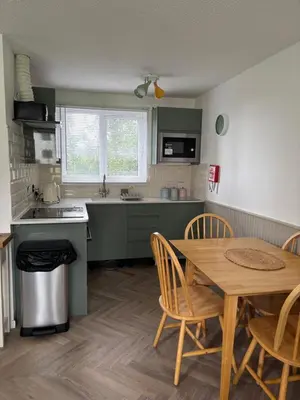 a kitchen with a wooden table and a table and chairs at 85 Strawberry Hill Hayle in Hayle