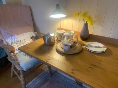 a wooden table with a glass jar on top of it at Phoenix Farm Shepherds Hut in Liskeard