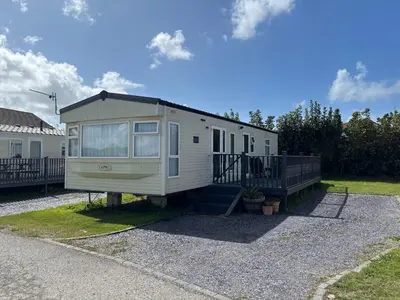 a tiny house sitting on top of a gravel driveway at Seaside Escape 2-Bed Caravan at Seven Bays Park in St Merryn