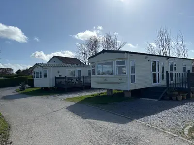 a tiny house sitting on the side of a driveway at Seaside Escape 2-Bed Caravan at Seven Bays Park in St Merryn