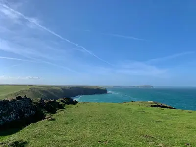 a green field with a view of the ocean at Seaside Escape 2-Bed Caravan at Seven Bays Park in St Merryn