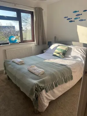 a bedroom with a bed with two towels on it at Tranquil one bed flat in Newquay