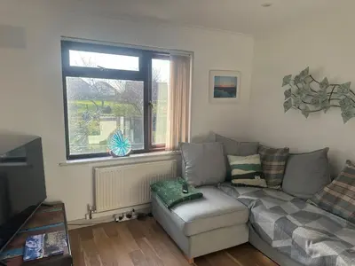 a living room with a couch and a window at Tranquil one bed flat in Newquay