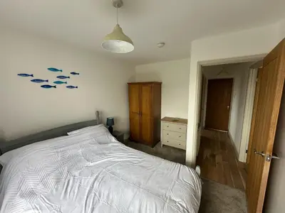 a bedroom with a bed with fish on the wall at Tranquil one bed flat in Newquay