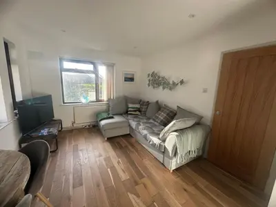 a living room with a couch and a window at Tranquil one bed flat in Newquay