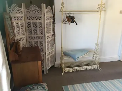 a room with a mirror and a chair at Cornish Cottage in Newquay