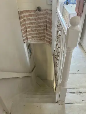 a stairway with a towel hanging on a rail at Cornish Cottage in Newquay