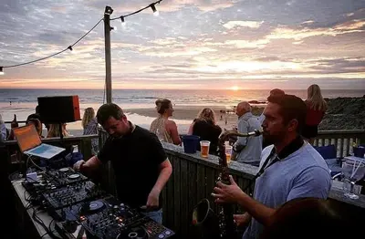 a group of people at a bar with the beach at Cornish Cottage in Newquay