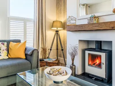 a living room with a fireplace and a couch at Holiday Home Lighthouse Watch by Interhome in Mevagissey