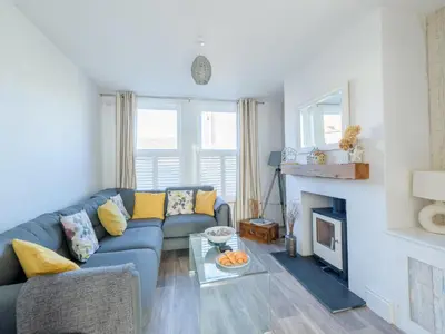 a living room with a blue couch and a fireplace at Holiday Home Lighthouse Watch by Interhome in Mevagissey