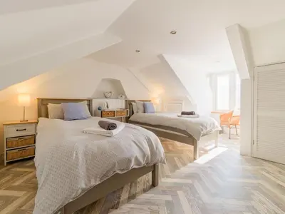 two beds in a room with white walls at Holiday Home Lighthouse Watch by Interhome in Mevagissey