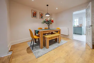 a dining room with a wooden table and yellow chairs at KAOLIN Splendid Cornwall Home By STAE Homes in St Austell