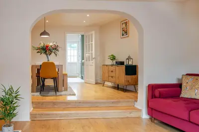 a living room with a red couch and a table at KAOLIN Splendid Cornwall Home By STAE Homes in St Austell