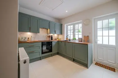 a kitchen with green cabinets and a window at KAOLIN Splendid Cornwall Home By STAE Homes in St Austell