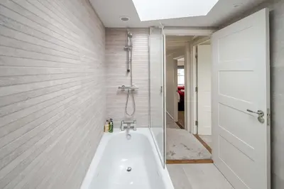 a bathroom with a bath tub and a shower at KAOLIN Splendid Cornwall Home By STAE Homes in St Austell