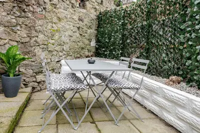 a table and two chairs sitting next to a wall at KAOLIN Splendid Cornwall Home By STAE Homes in St Austell