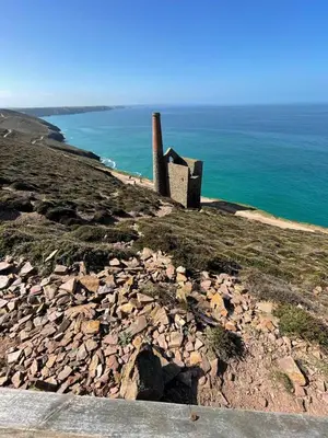 a pile of rocks on a hill next to the ocean at Wheal Rock - Luxury 2 Bed Lodge in St. Agnes