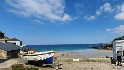 a boat sitting on the shore of a beach at Wheal Rock - Luxury 2 Bed Lodge in St. Agnes