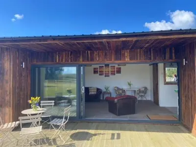 a living room with a large sliding glass door at Wheal Rock - Luxury 2 Bed Lodge in St. Agnes